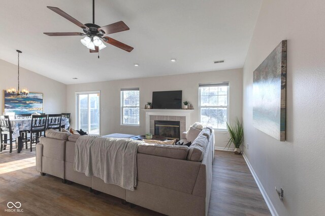 living area featuring a tiled fireplace, wood finished floors, visible vents, and a wealth of natural light