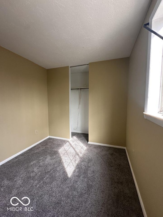 unfurnished bedroom with carpet, baseboards, a closet, and a textured ceiling