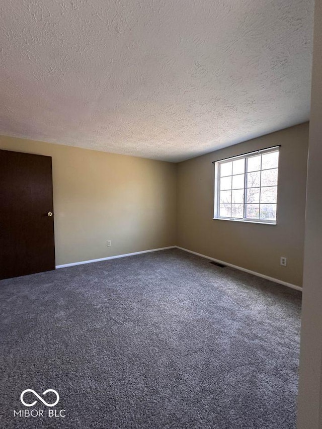 carpeted spare room featuring baseboards, visible vents, and a textured ceiling