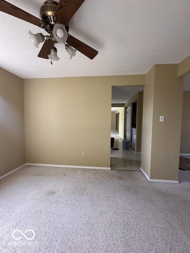 carpeted empty room with baseboards, a textured ceiling, and ceiling fan