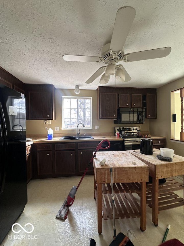 kitchen with a sink, dark brown cabinetry, black appliances, and a ceiling fan