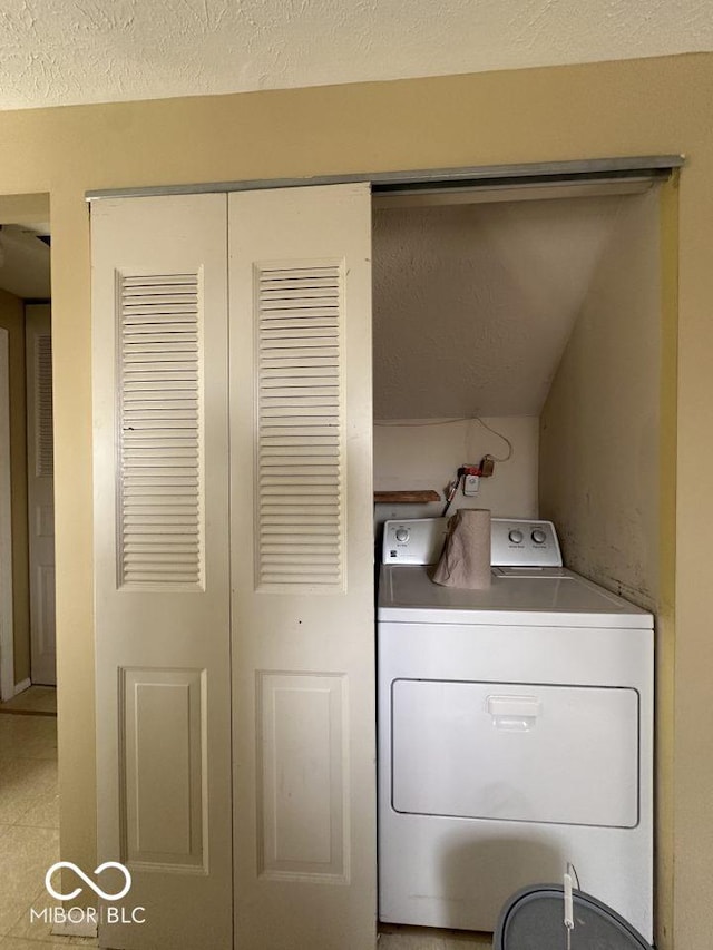 laundry room featuring laundry area, washer / dryer, and a textured ceiling