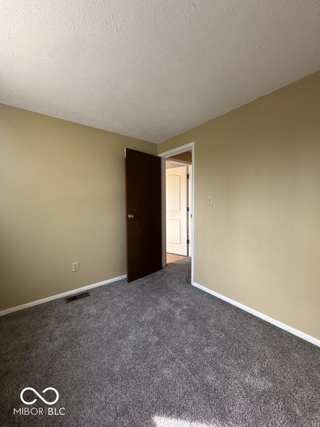 carpeted empty room with visible vents, baseboards, and a textured ceiling