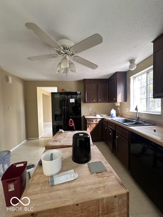 kitchen featuring black appliances, a sink, light countertops, dark brown cabinets, and ceiling fan