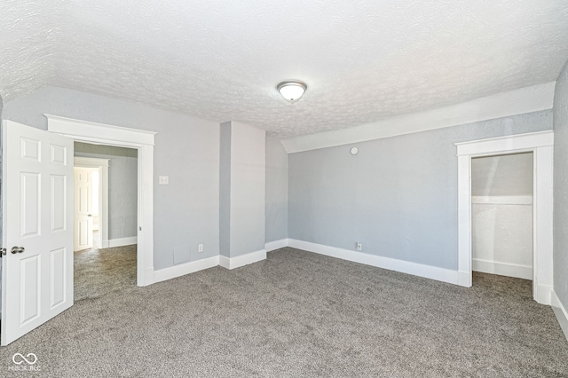 unfurnished bedroom with carpet flooring, baseboards, and a textured ceiling