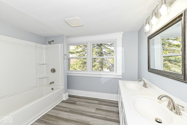 full bathroom with a sink, baseboards, bathing tub / shower combination, and wood finished floors