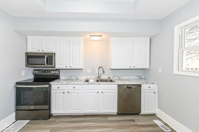 kitchen with white cabinetry, visible vents, appliances with stainless steel finishes, and a sink