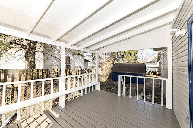 deck featuring an outbuilding, a fenced backyard, and a shed