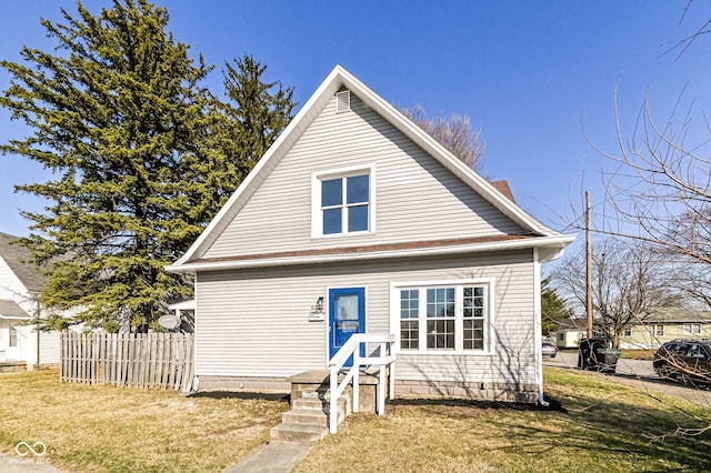 bungalow-style home featuring a front lawn and fence