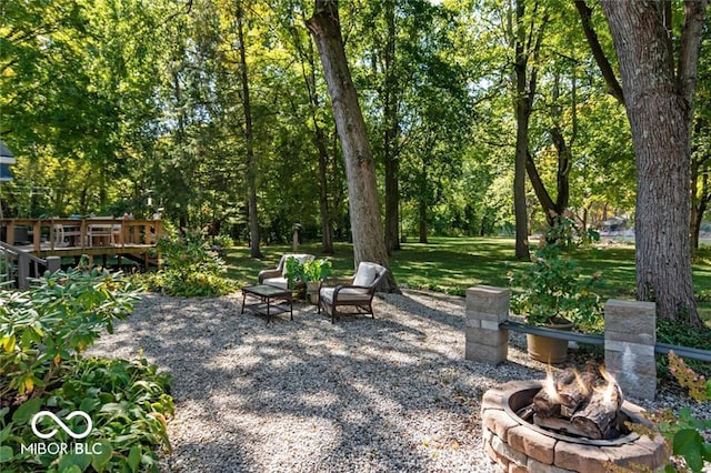 view of patio / terrace with a wooden deck and an outdoor fire pit