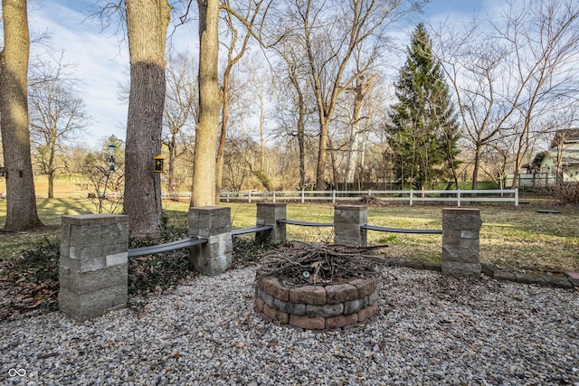 view of yard with fence and an outdoor fire pit