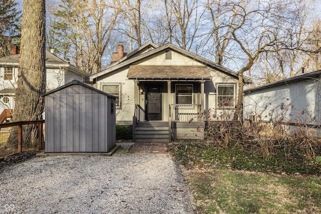 bungalow-style home featuring an outdoor structure, a chimney, and a shed