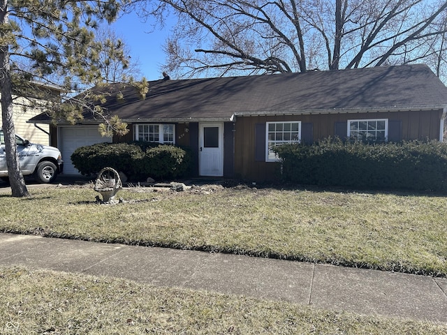 ranch-style house featuring a garage, board and batten siding, and a front lawn