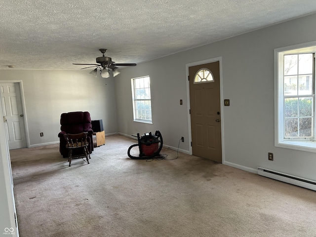 entryway with a baseboard heating unit, baseboards, carpet, and a ceiling fan