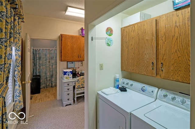 laundry area featuring cabinet space, washing machine and dryer, and light colored carpet