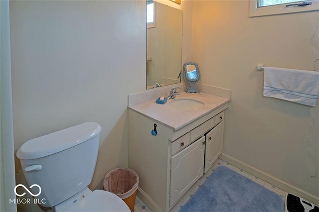 half bath with vanity, toilet, and baseboards