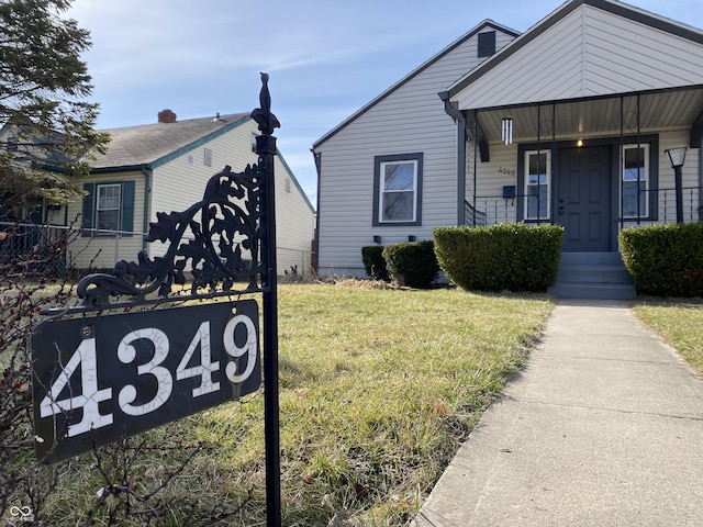 bungalow with a porch, a front yard, and fence