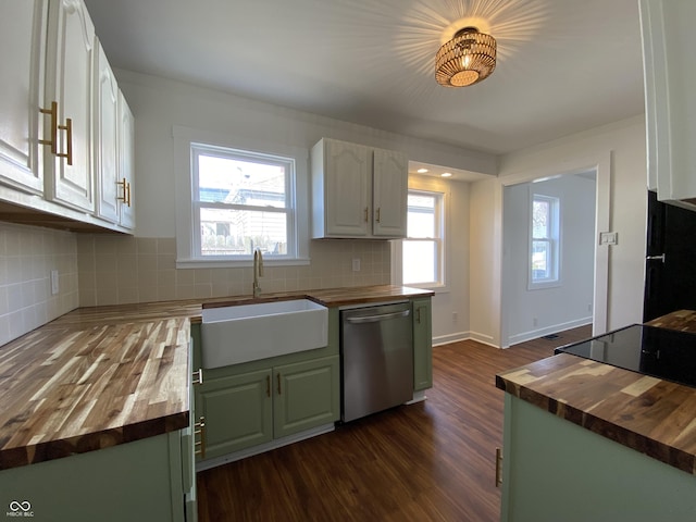 kitchen featuring wooden counters, dishwasher, green cabinets, and a sink