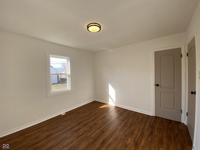 unfurnished room featuring dark wood finished floors and baseboards