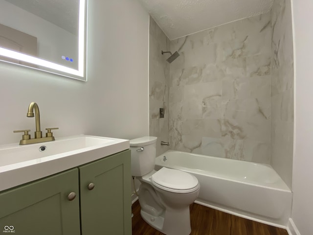 bathroom with toilet, a textured ceiling, shower / washtub combination, wood finished floors, and vanity