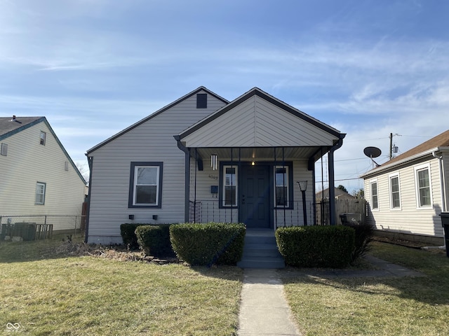 view of front facade with a front lawn, fence, and covered porch