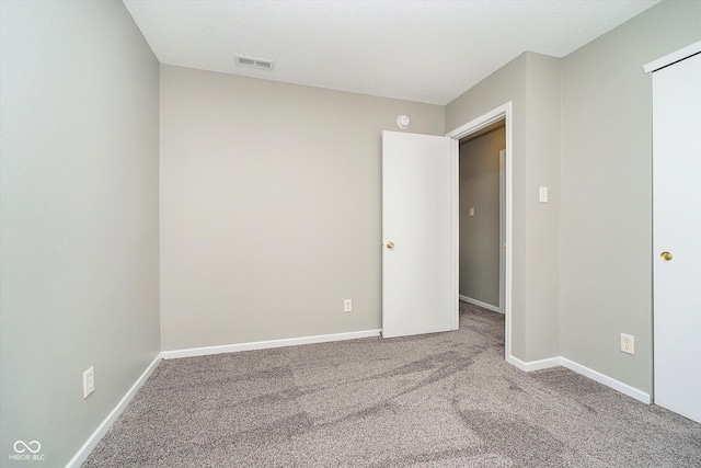 unfurnished bedroom with visible vents, baseboards, and carpet