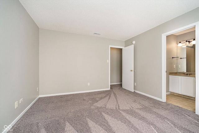 unfurnished bedroom with light colored carpet, visible vents, and baseboards