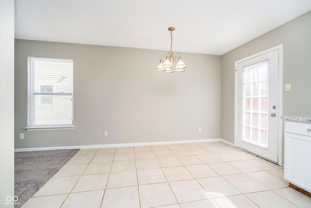 unfurnished room featuring light tile patterned floors, baseboards, and a notable chandelier