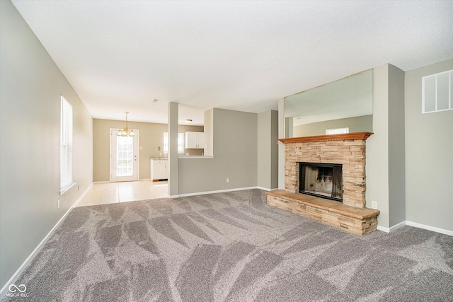 unfurnished living room featuring visible vents, light carpet, baseboards, and a chandelier