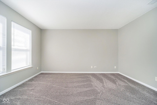 carpeted empty room featuring visible vents and baseboards