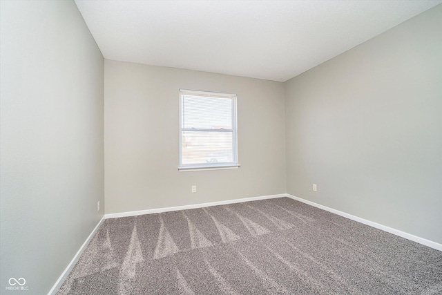 empty room featuring baseboards and carpet