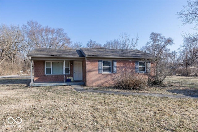 ranch-style house featuring a front yard, covered porch, and brick siding