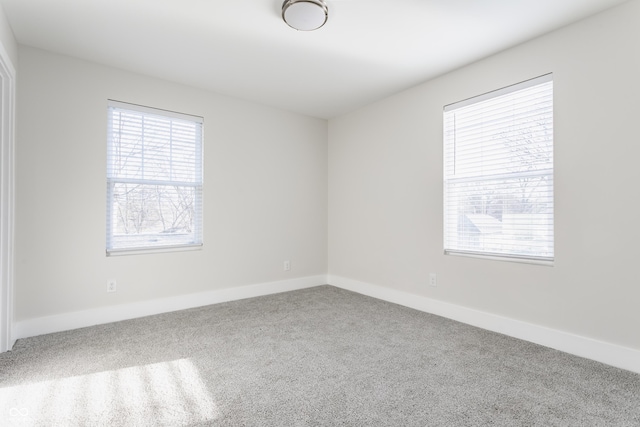 carpeted empty room with baseboards