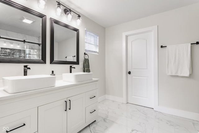 bathroom with a sink, baseboards, marble finish floor, and a stall shower