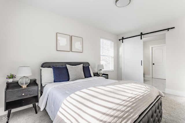 bedroom featuring light colored carpet, baseboards, and a barn door