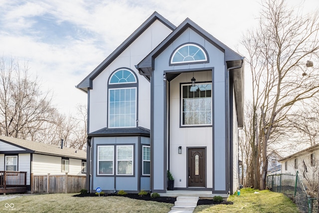 view of front of property featuring stucco siding, a front lawn, and fence