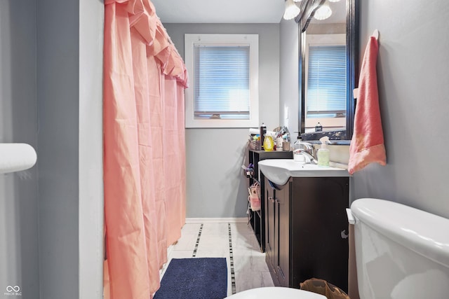 full bathroom with a shower with shower curtain, baseboards, toilet, and vanity