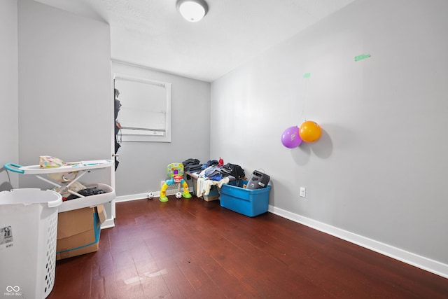 recreation room with baseboards and wood-type flooring