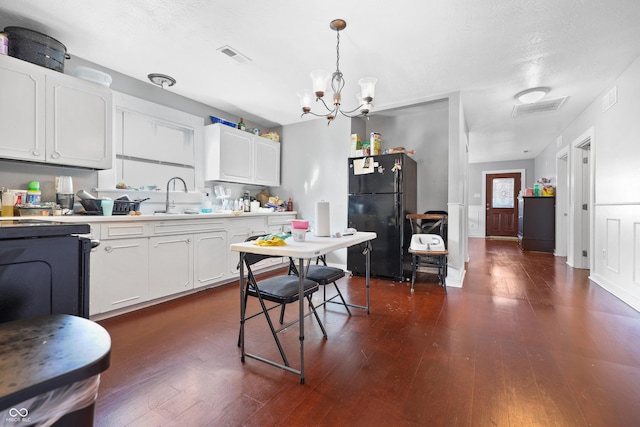 kitchen with a sink, dark wood-type flooring, light countertops, and freestanding refrigerator