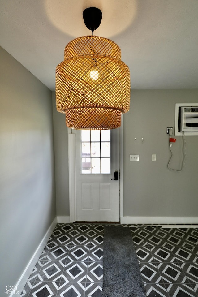 doorway to outside featuring carpet flooring, baseboards, and a wall mounted air conditioner