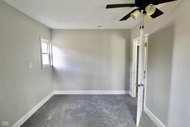 carpeted empty room with baseboards and a ceiling fan