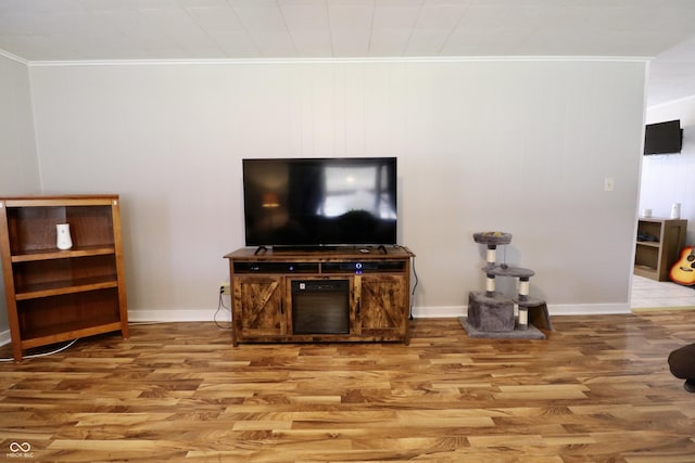 living room with baseboards, wood finished floors, and ornamental molding