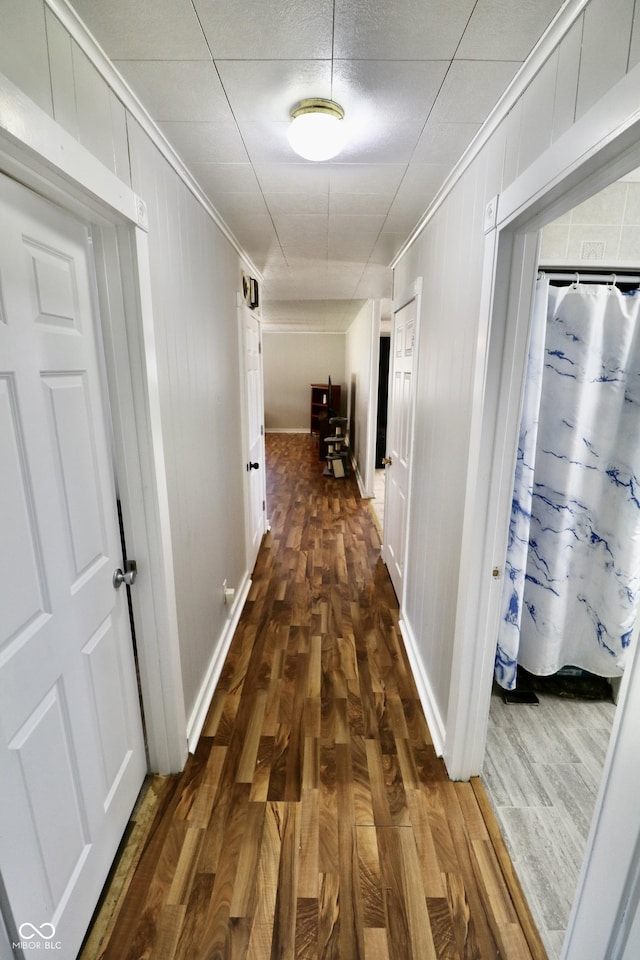 hall with crown molding and dark wood-style flooring