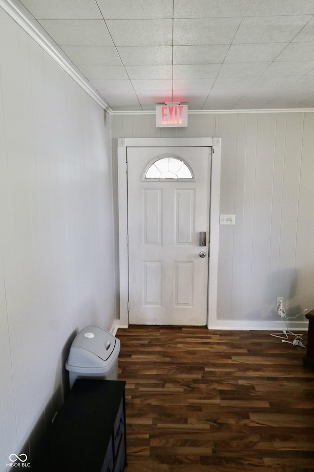 doorway to outside featuring dark wood finished floors, baseboards, and ornamental molding