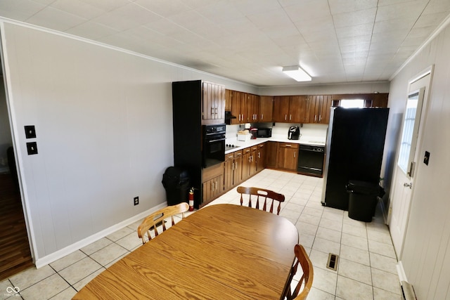 kitchen featuring black appliances, ornamental molding, light countertops, light tile patterned floors, and baseboards