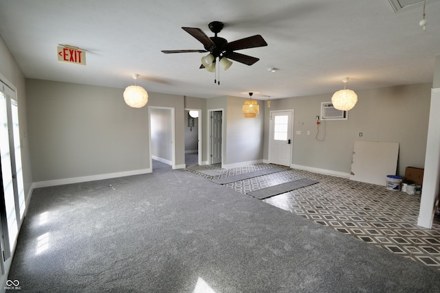 unfurnished living room featuring baseboards, an AC wall unit, ceiling fan, and carpet floors