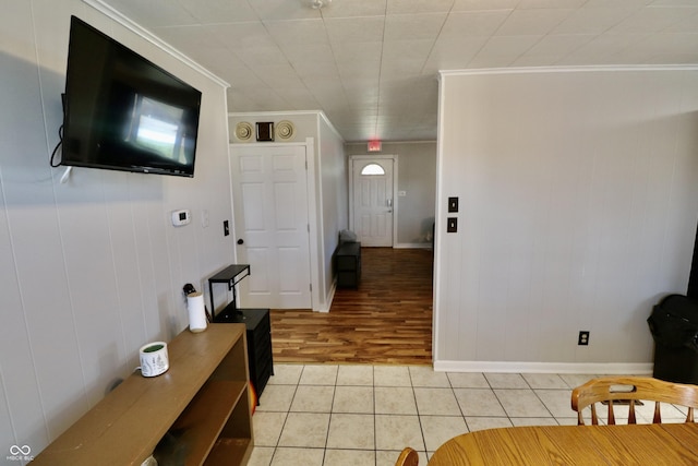 interior space featuring light tile patterned floors, crown molding, and baseboards