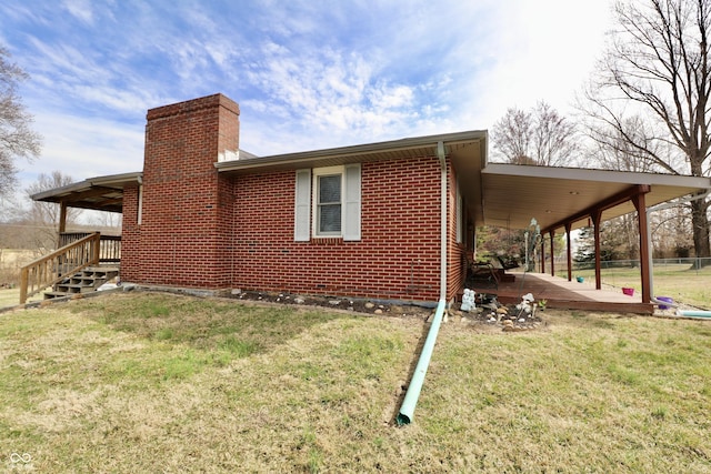 view of home's exterior with brick siding, a chimney, a yard, and fence