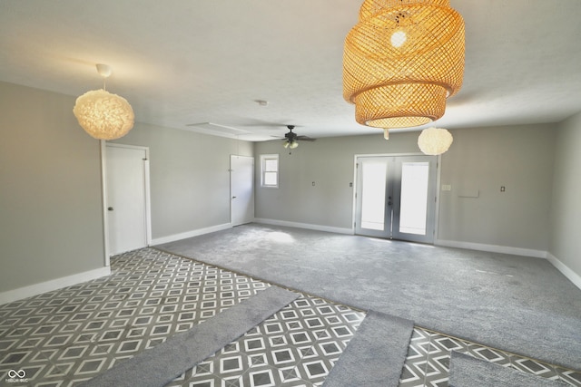 empty room featuring baseboards, attic access, ceiling fan, french doors, and carpet flooring