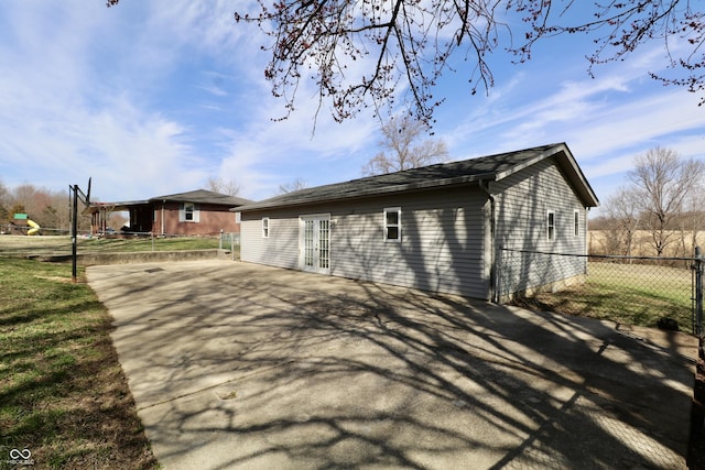 view of side of home featuring french doors and fence